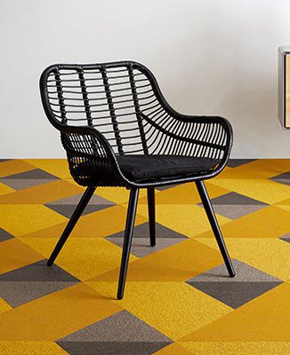 a black chair on a yellow floor with gray squares