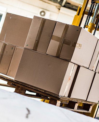 several cardboard boxes taped up and stacked on a pallette