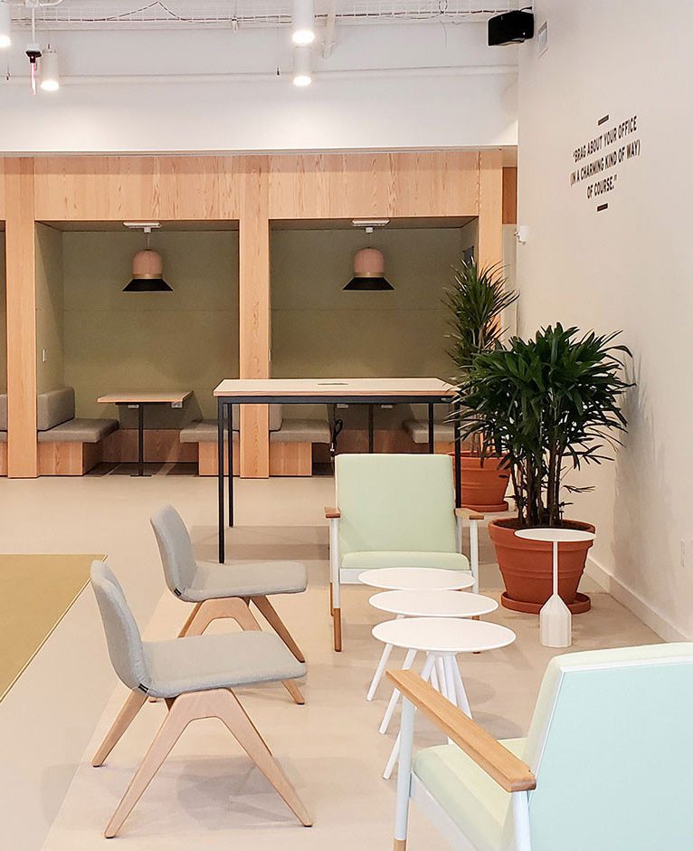 a sitting area with chairs, tables, and potted plants