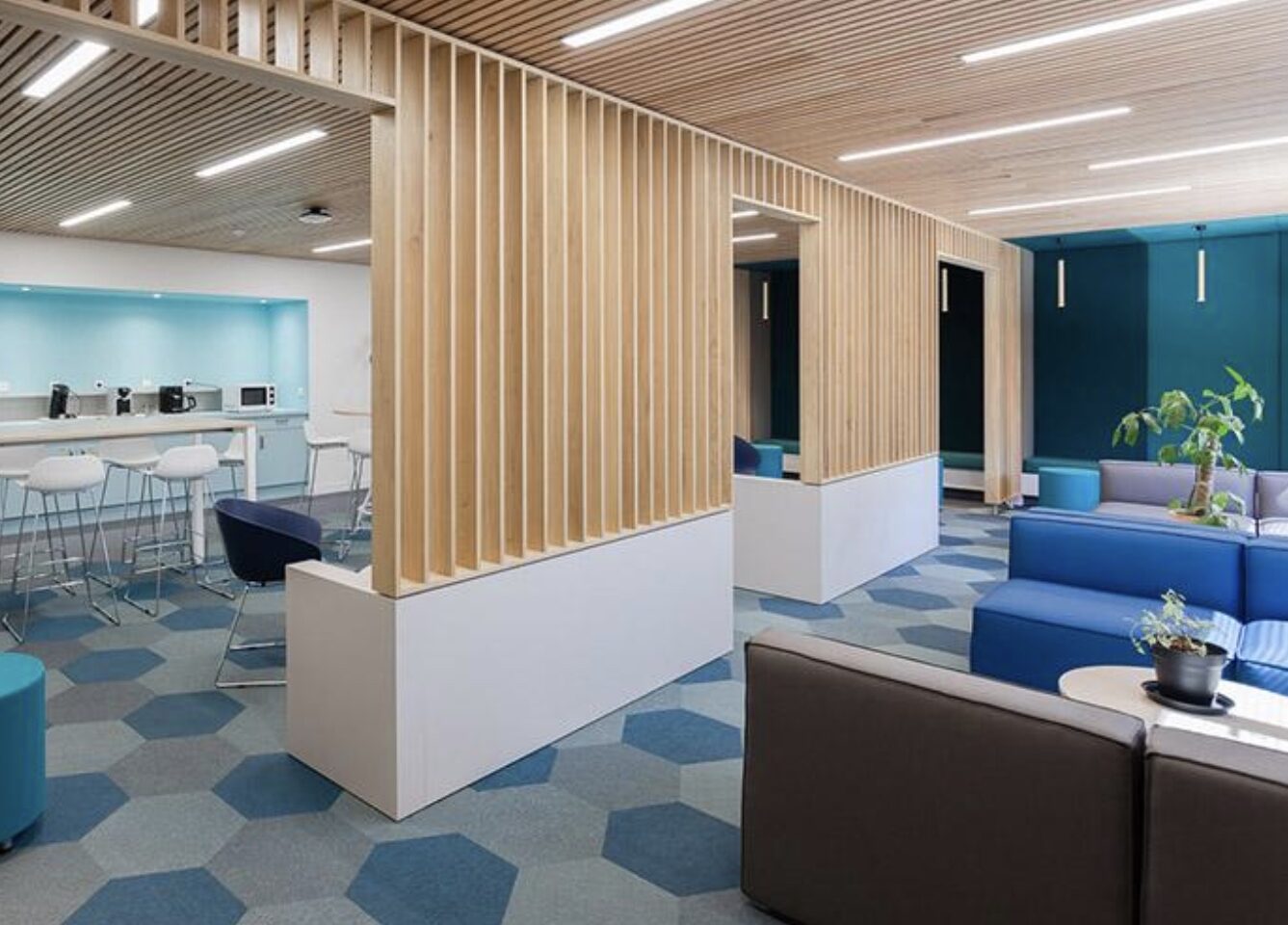 a lounge with couches, tables, stools, and blue and gray dickson flooring