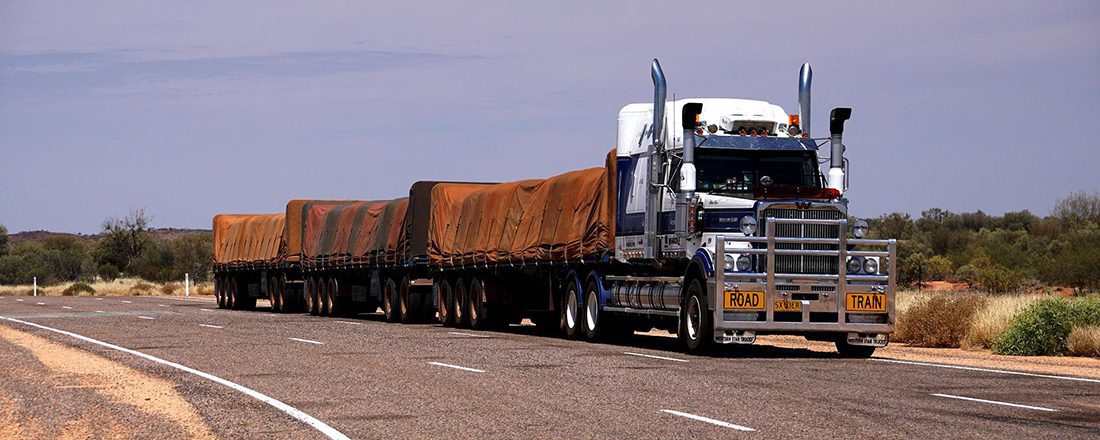 large truck with orange coverings drives down the highway