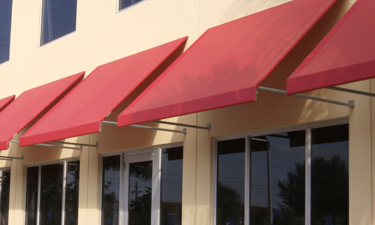 red awnings on the side of a yellow building