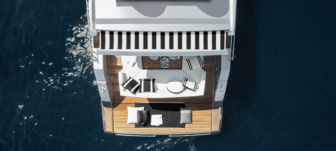 Overhead image of the back of a luxury boat with upholstered furniture