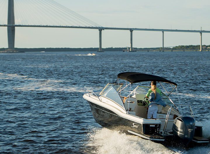 Couple riding a boat with a bridge in the background