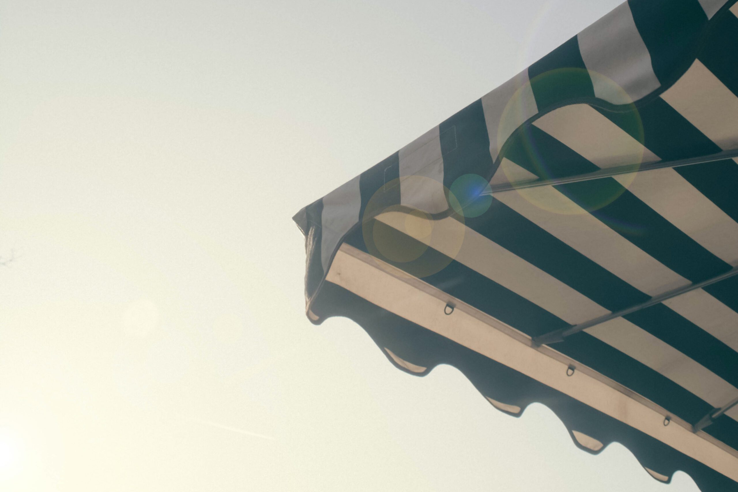 corner of a green striped awning