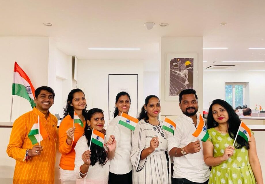 Strata Corporate team in India poses and holds Indian flags