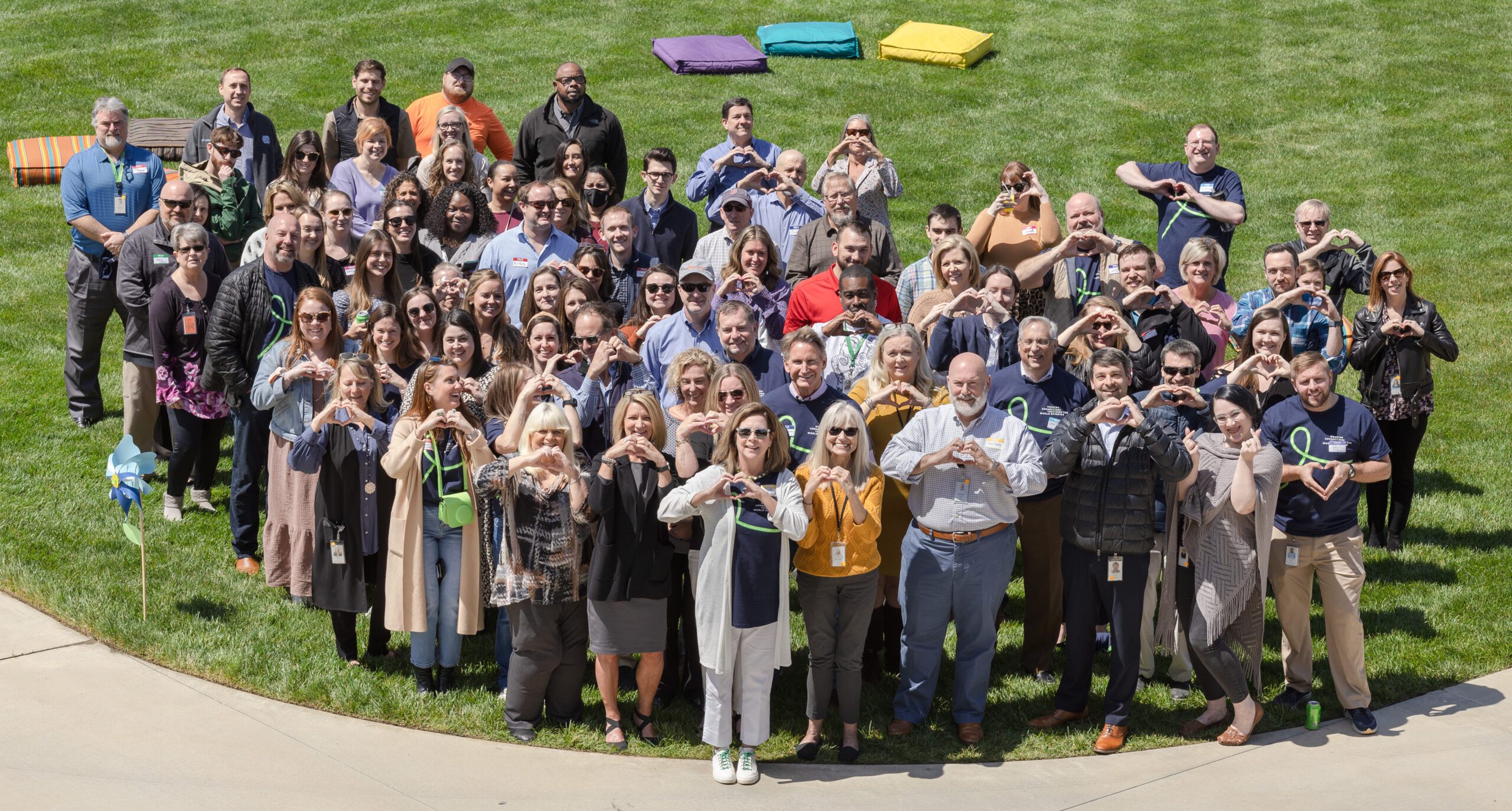 large group forming heart hands outside