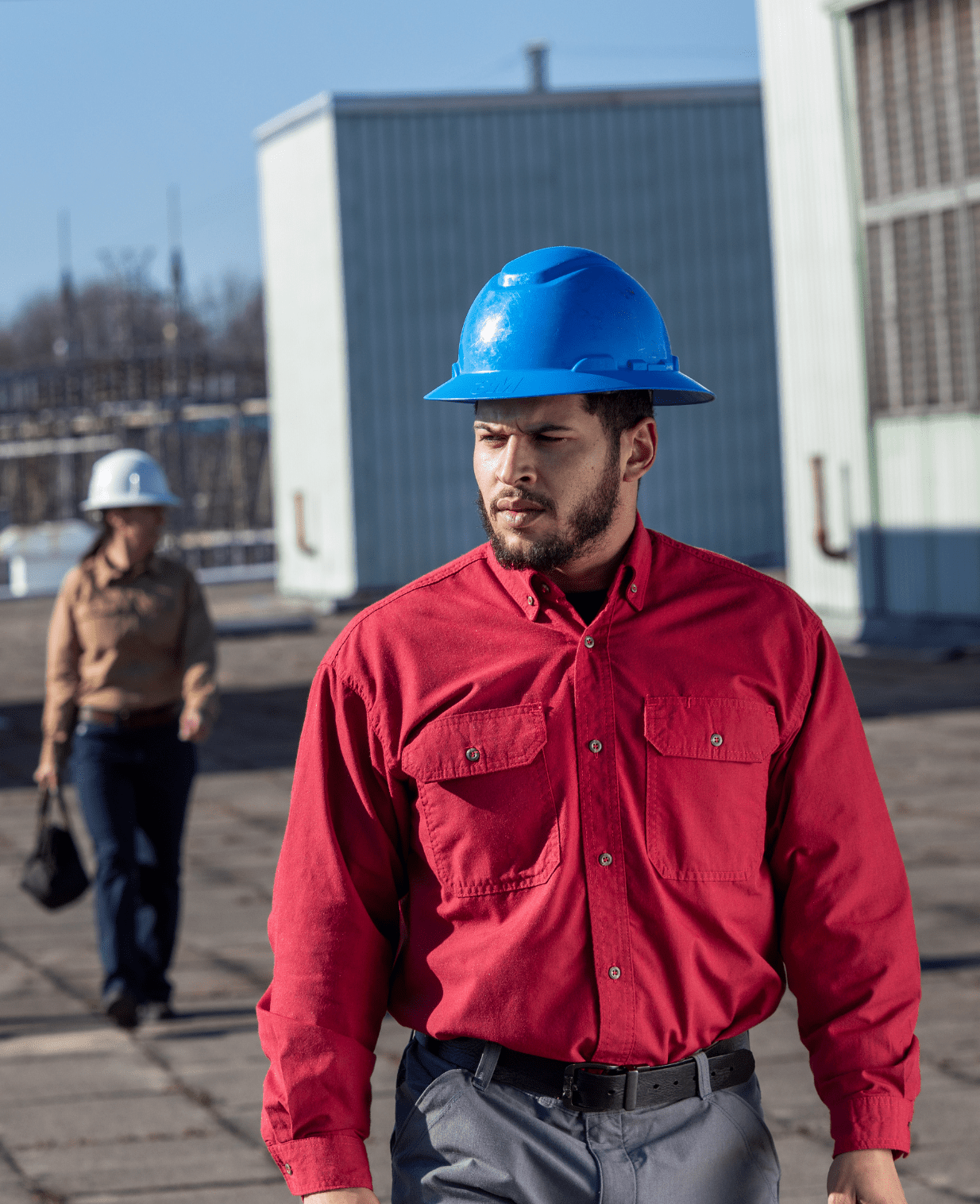 a man in a red protective shirt and blue hard hat